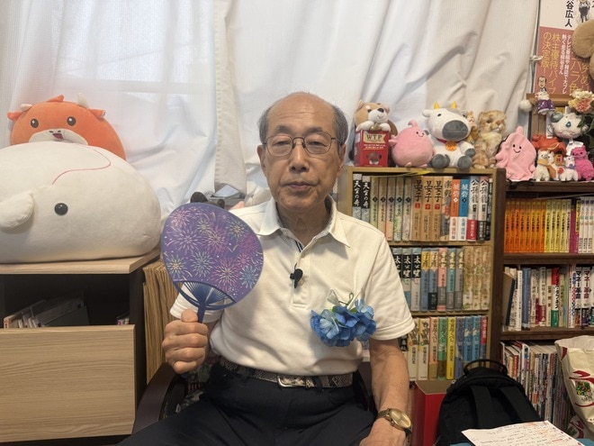 うちわを手にする桐谷広人さん